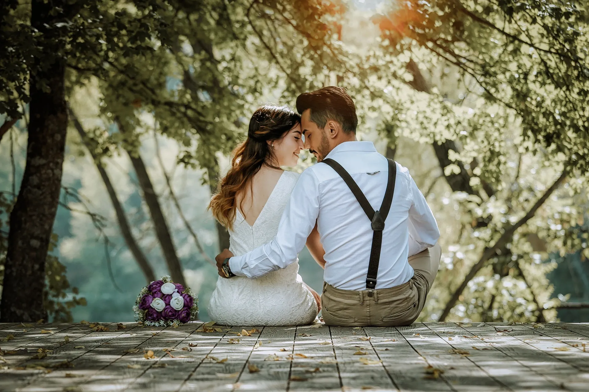Hochzeitspaar sitzt auf Holzboden