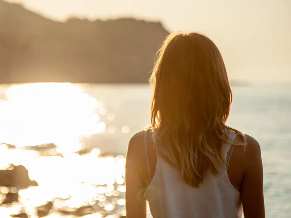Frau am Strand bei Sonnenuntergang