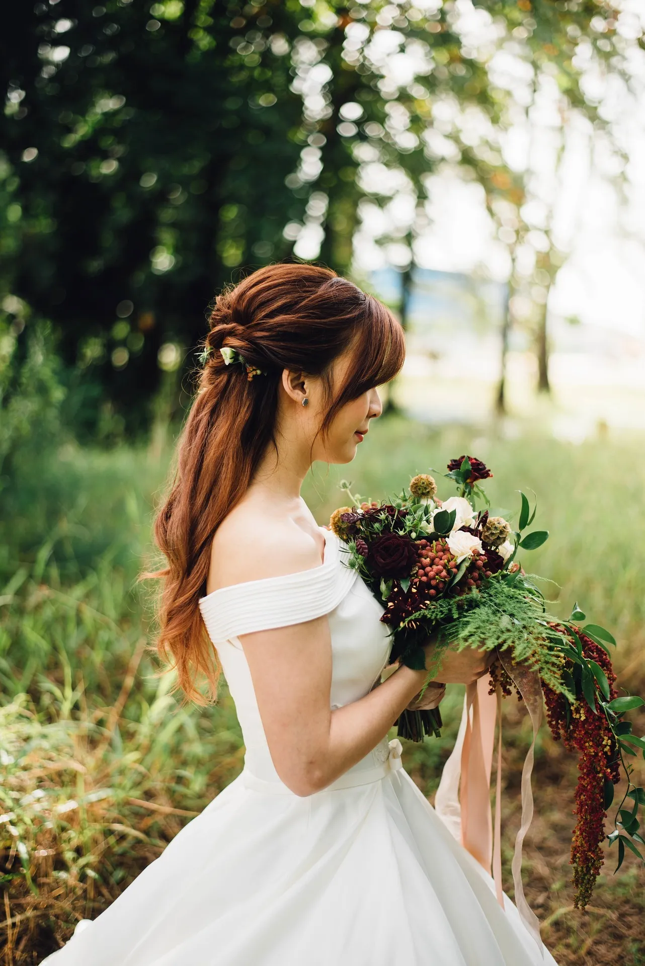 Frau in Brautkleid hält Blumenstrauß
