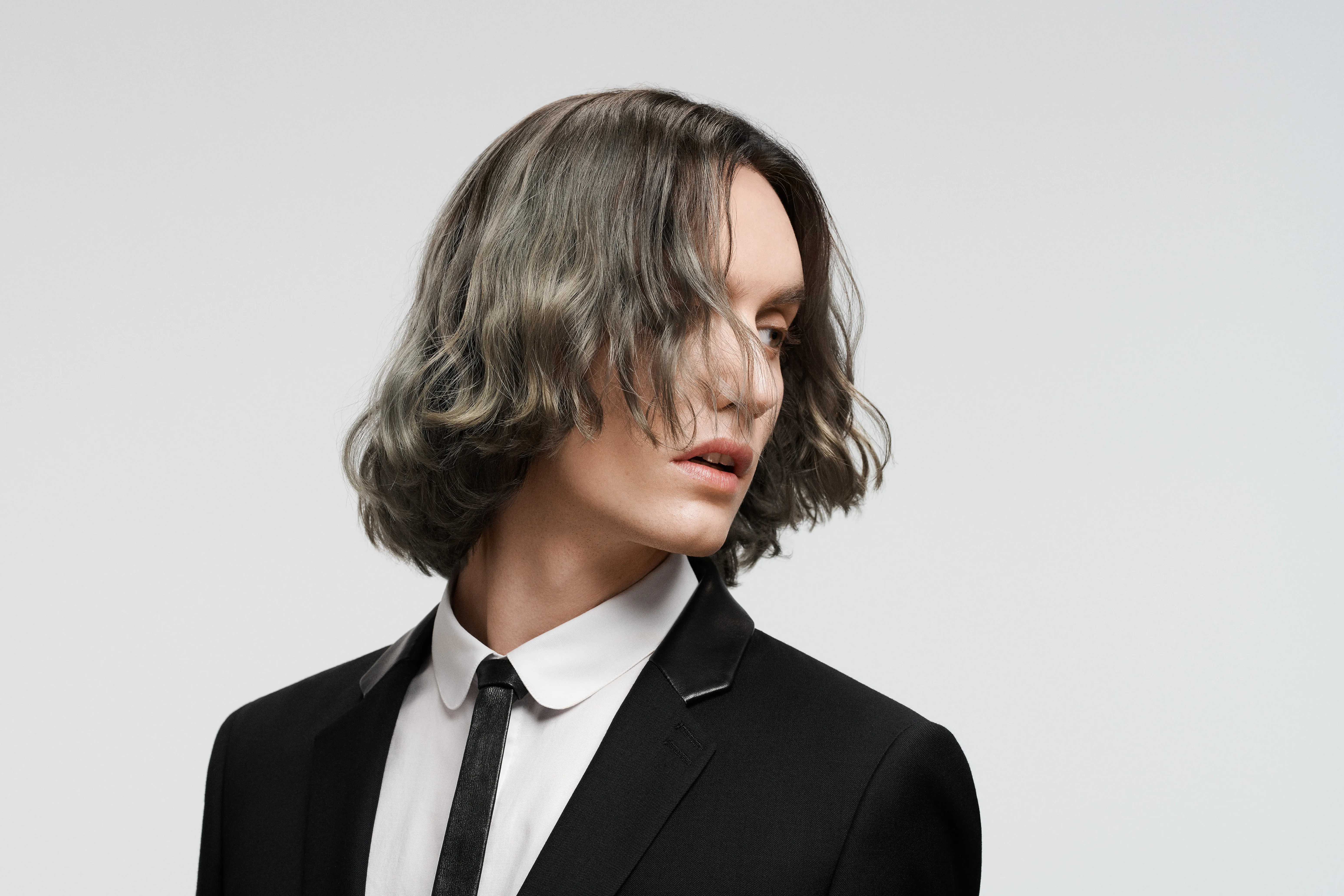 Mann mit Surfer Frisur im Anzug