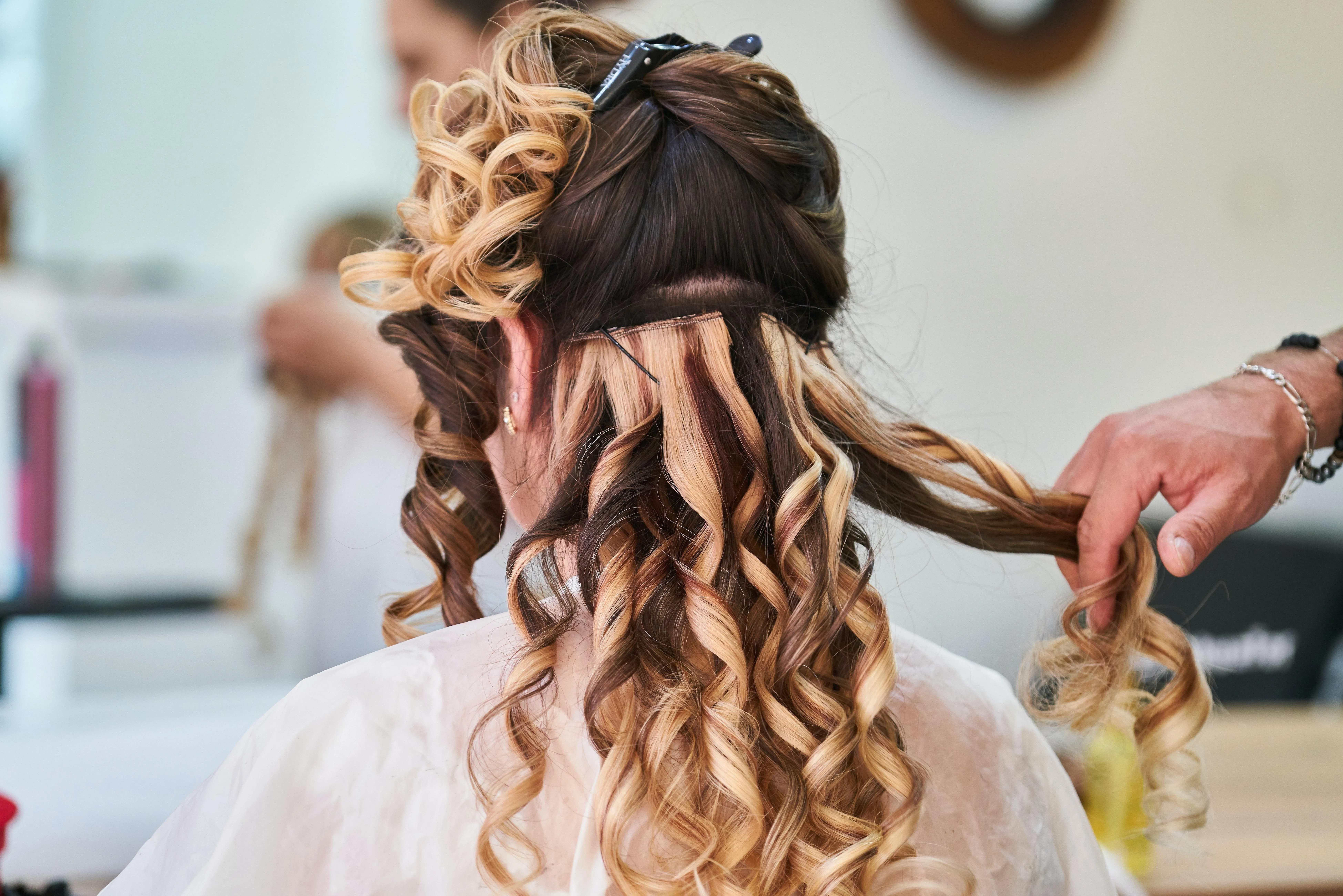 Frau werden lockige Extensions angebracht
