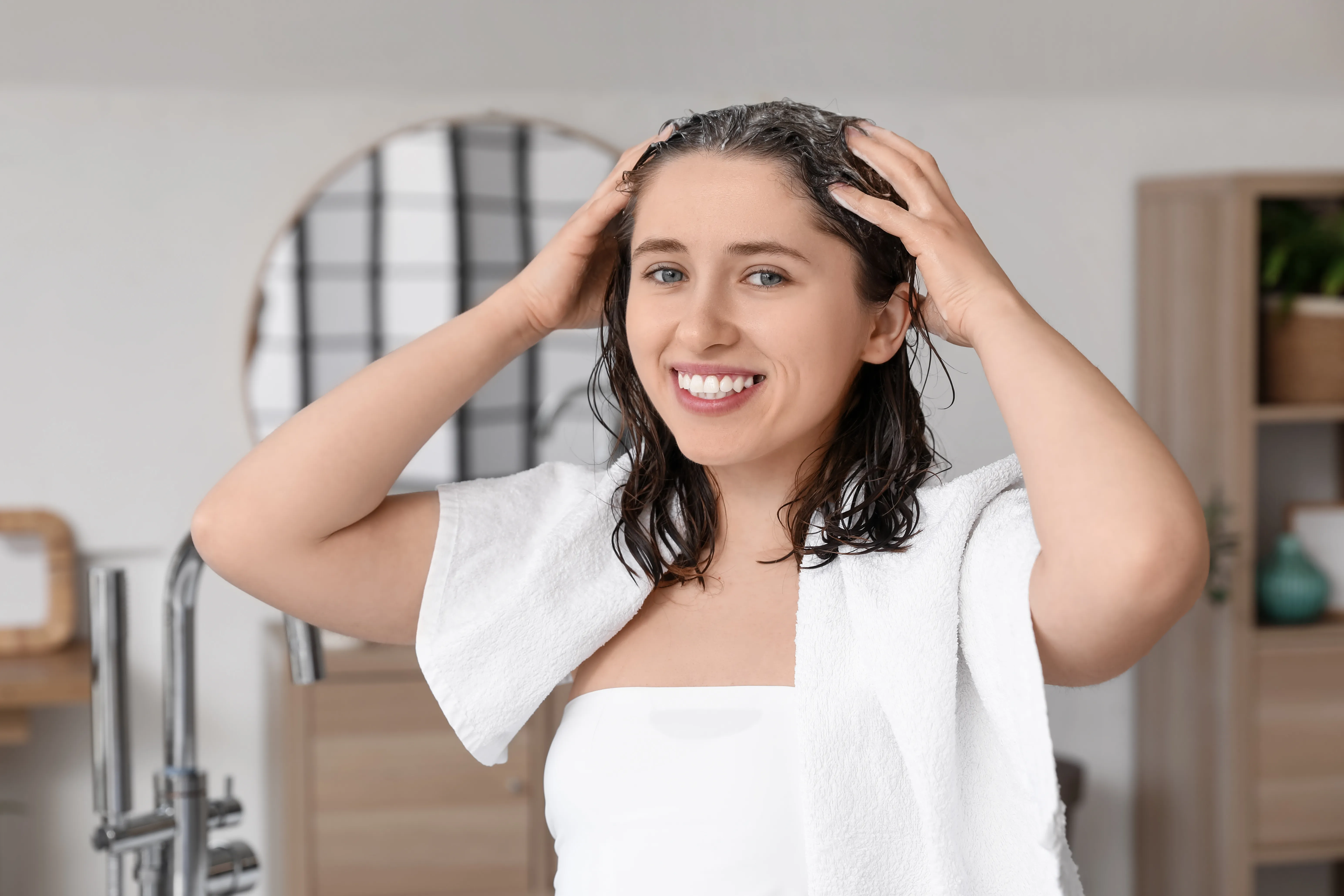 Frau fasst sich auf die Kopfhaut