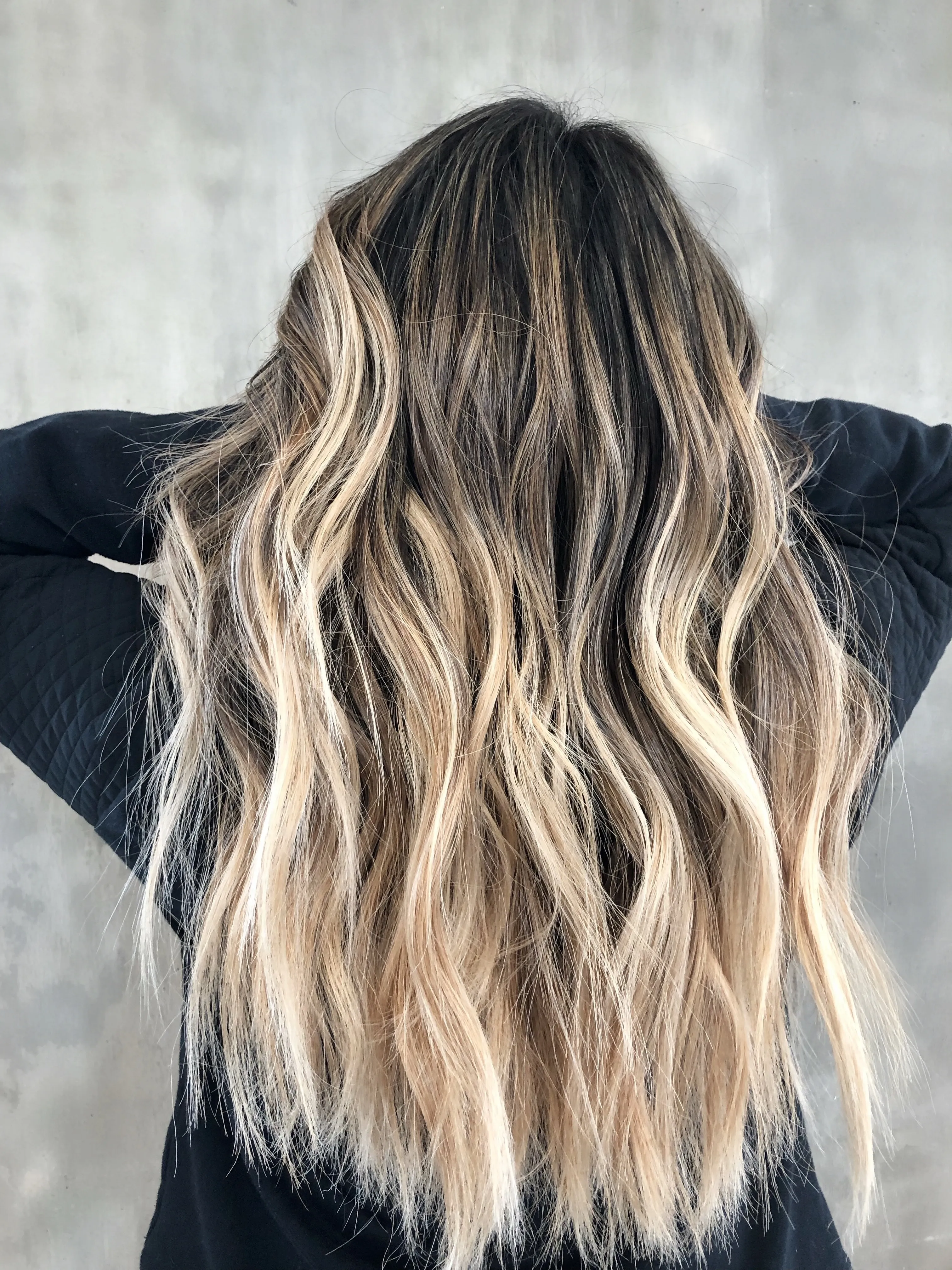 Frau mit langen blonden Haaren mi Balayage