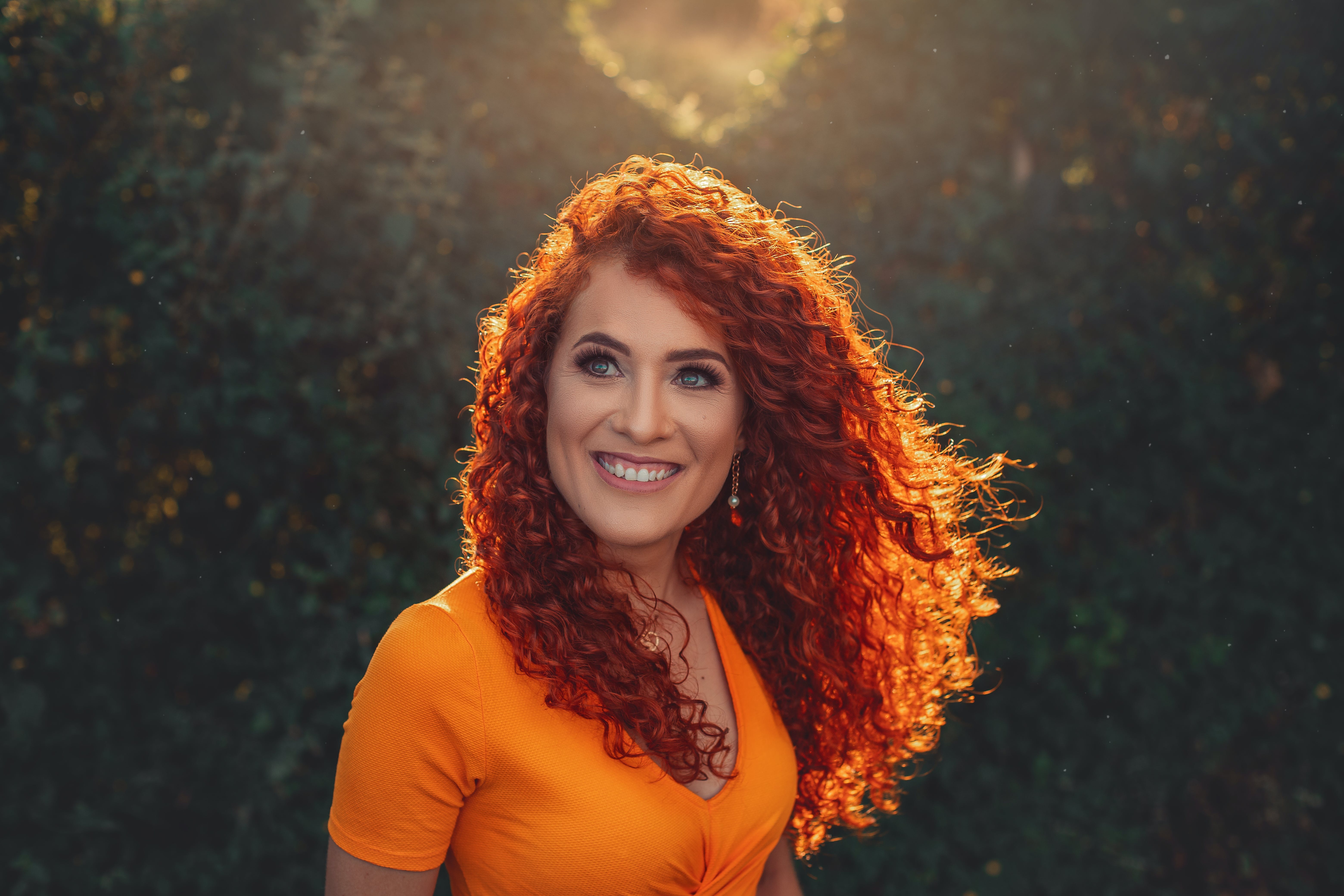 Frau mit langen roten lockigen Haaren und Butterfly Cut