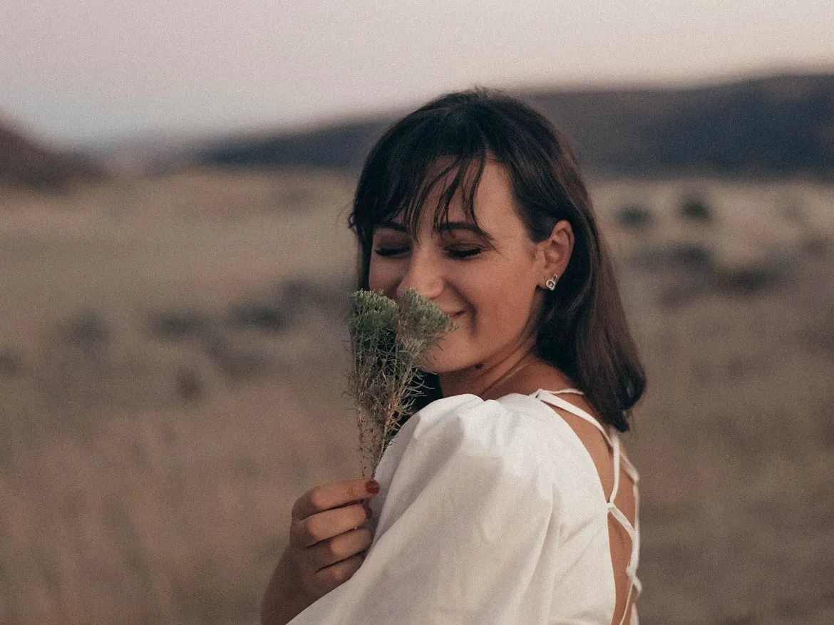 Brünette Frau mit Pflanze in der Hand