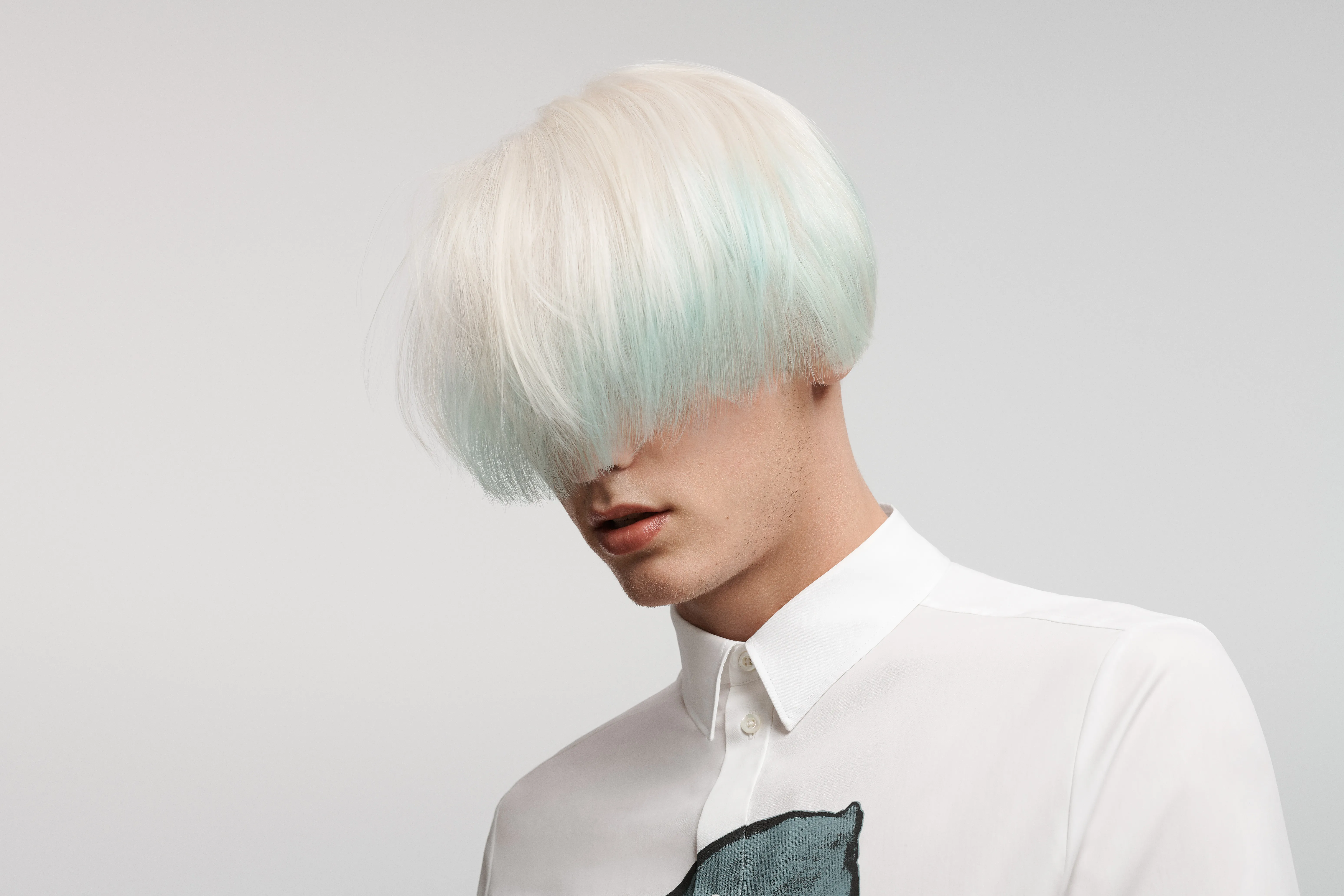 Blonder Mann mit Topfschnitt im weissen Hemd