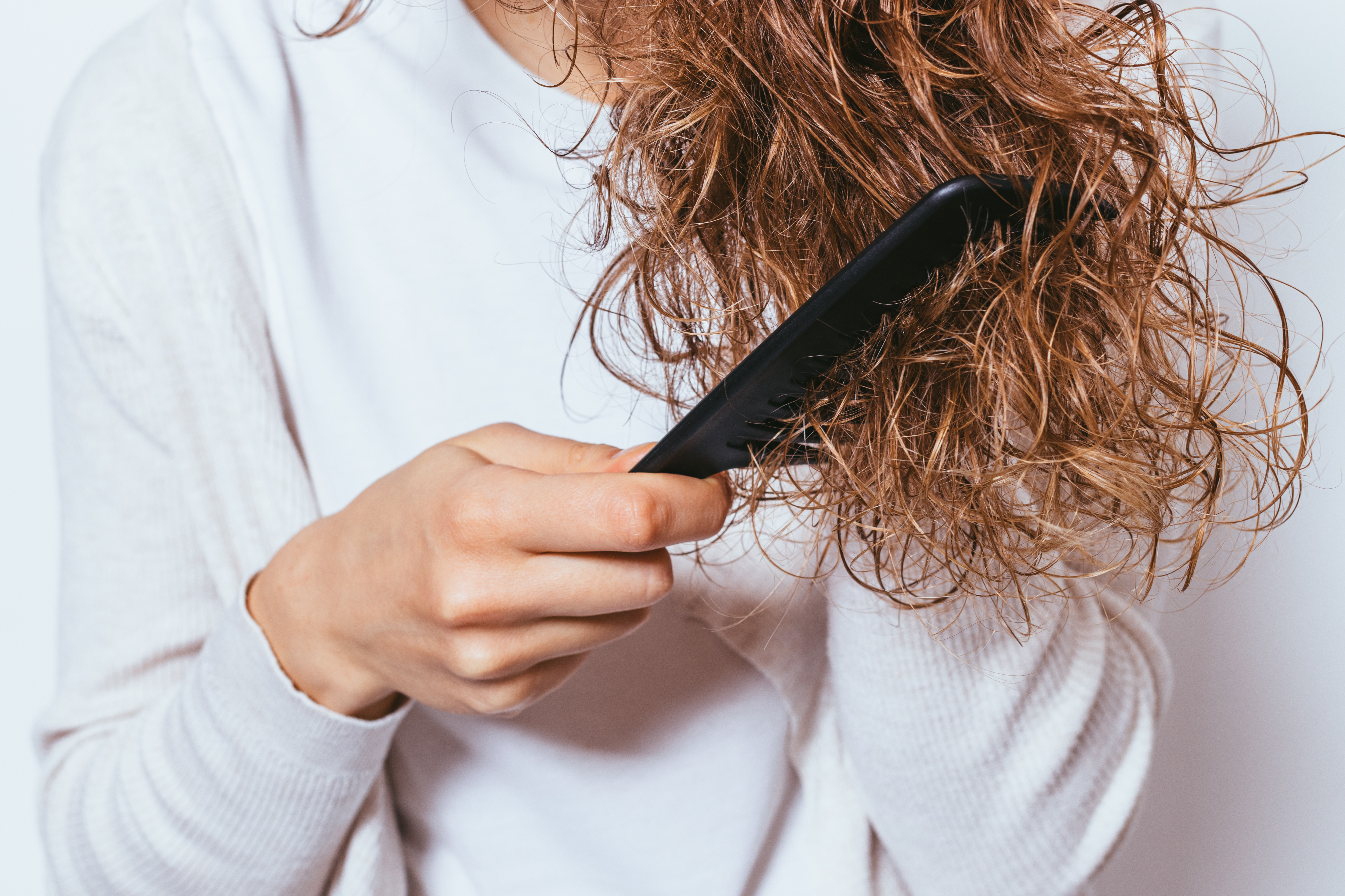 Frau kämmt verfilztes Haar